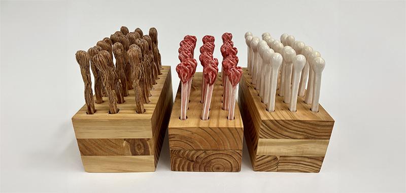 sculpture resembling matches mounted on wood boxes
