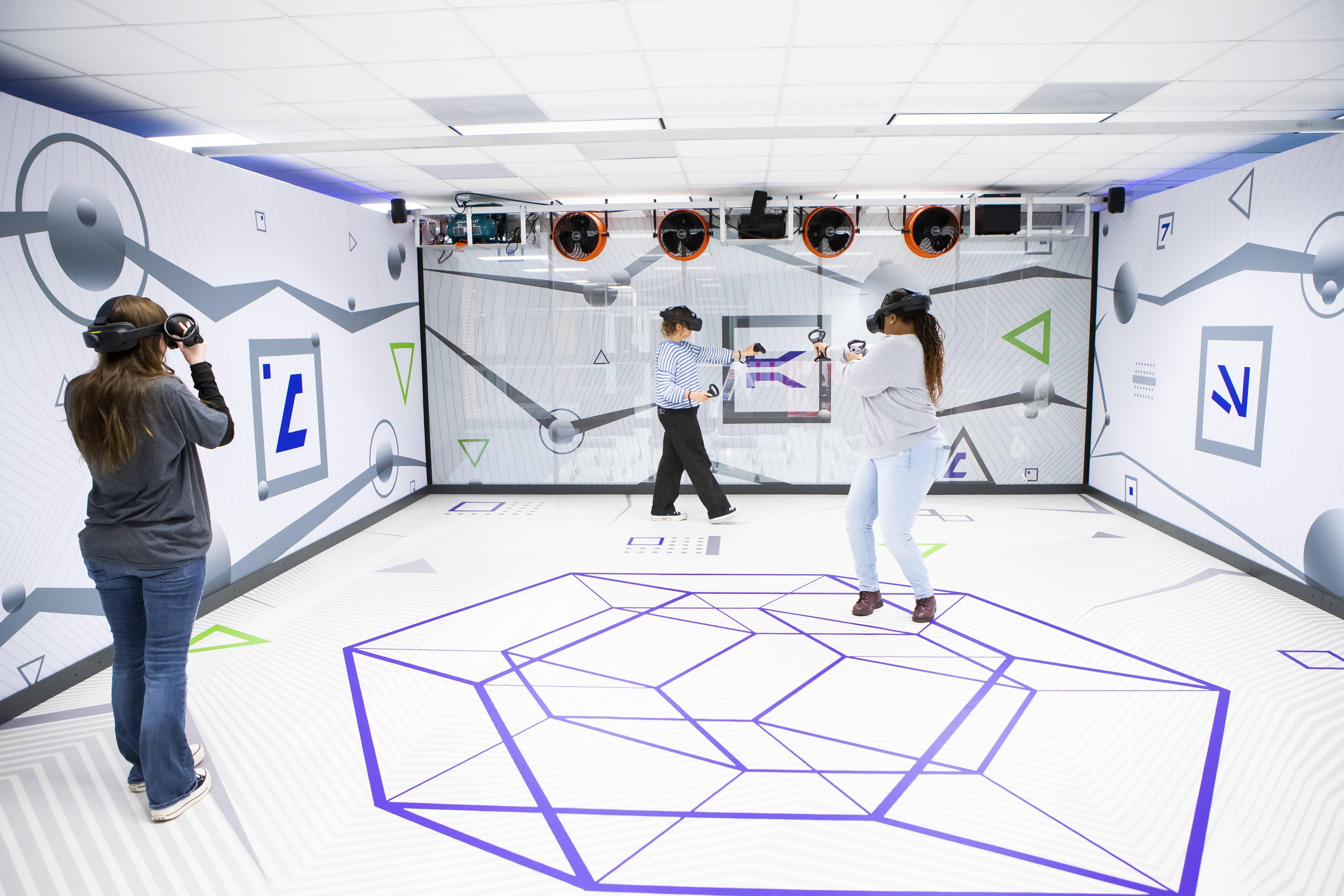 Three students playing a game in the Virtual Reality room.